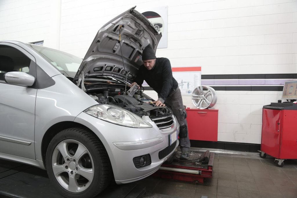 An image of a man fixing a high-mileage car