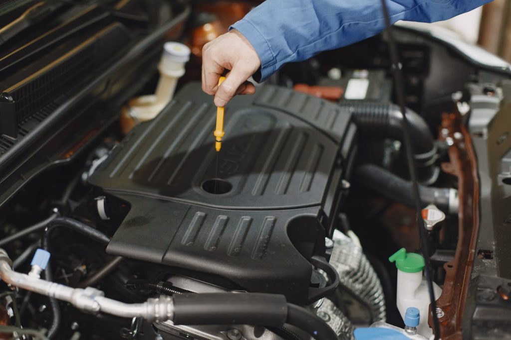 A mechanic checking a cars oil