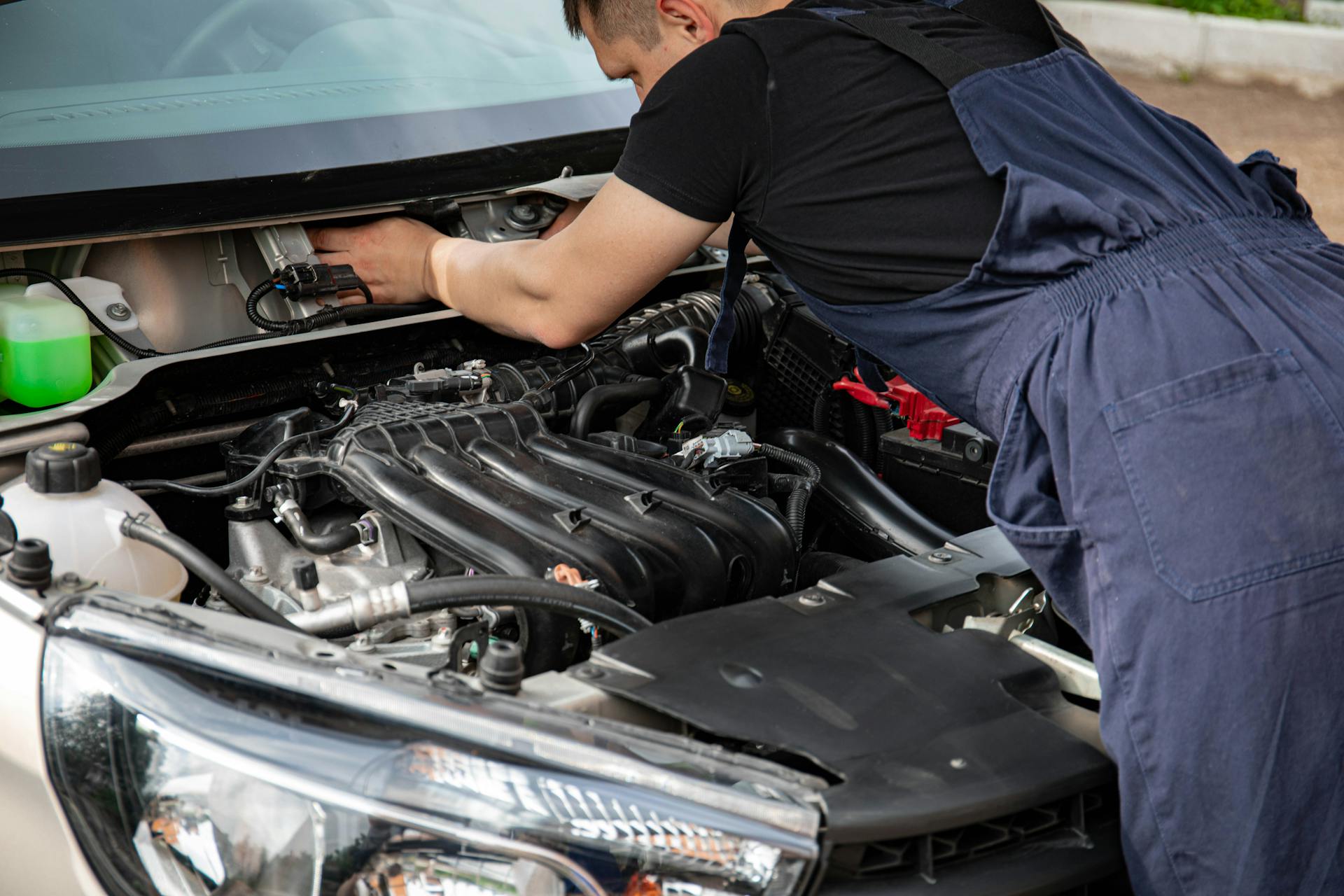 Man in Black Crew Neck T Shirt Fixing a Car